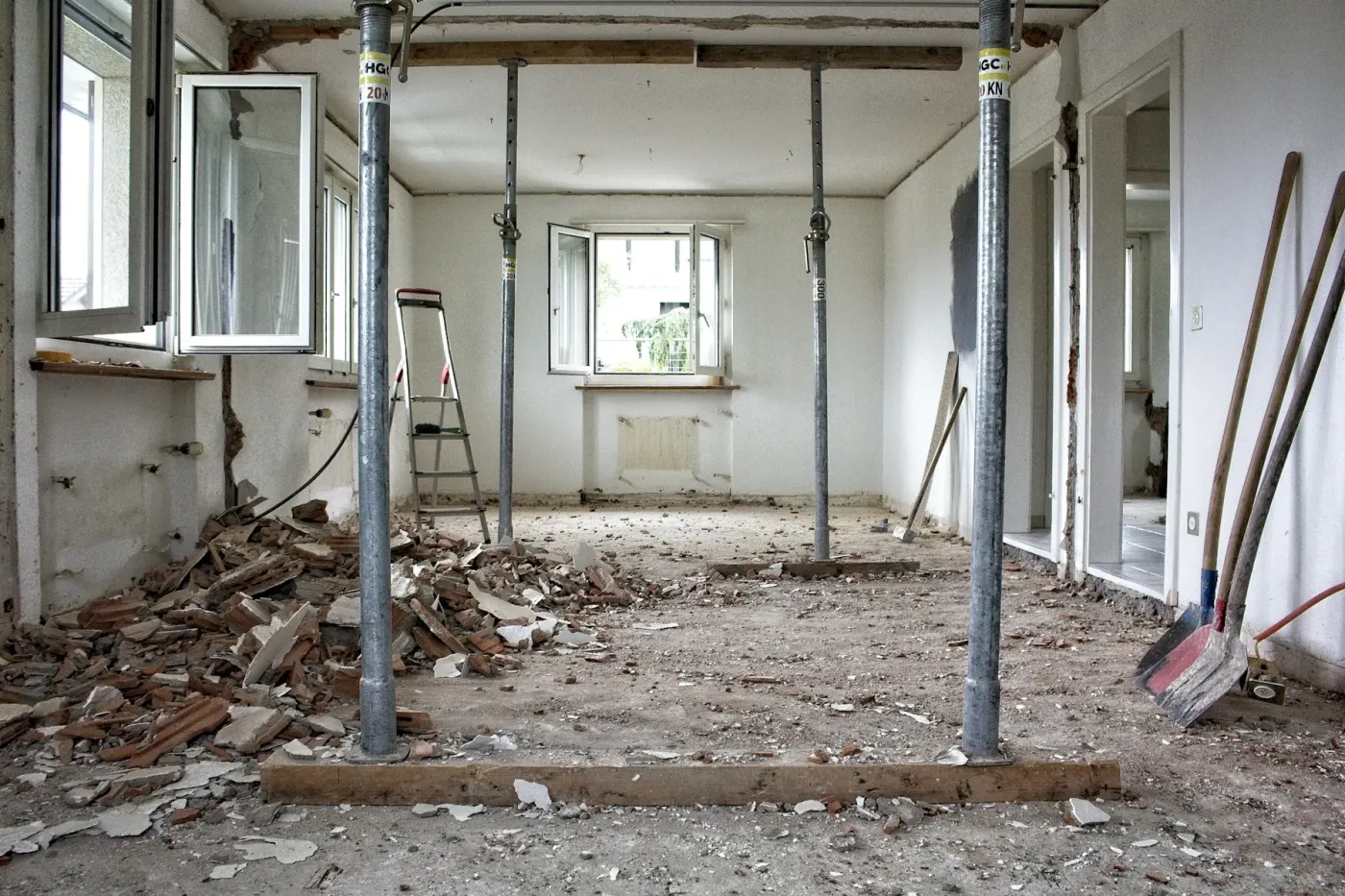 Rum under renovering med stödpelare, rivningsmaterial och verktyg