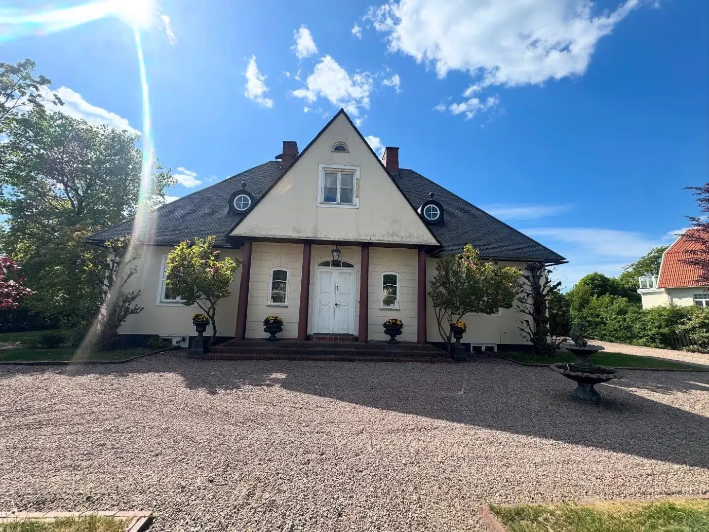 Ljus villa med flagnande fasad före fasadmålning